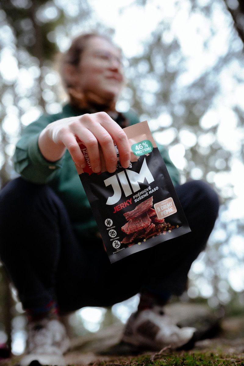 Žena v lese podává balíček JIM JERKY